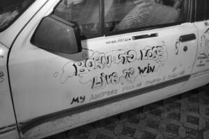 Born to lose, live to win — sequenced street series still (graffiti on a car door)