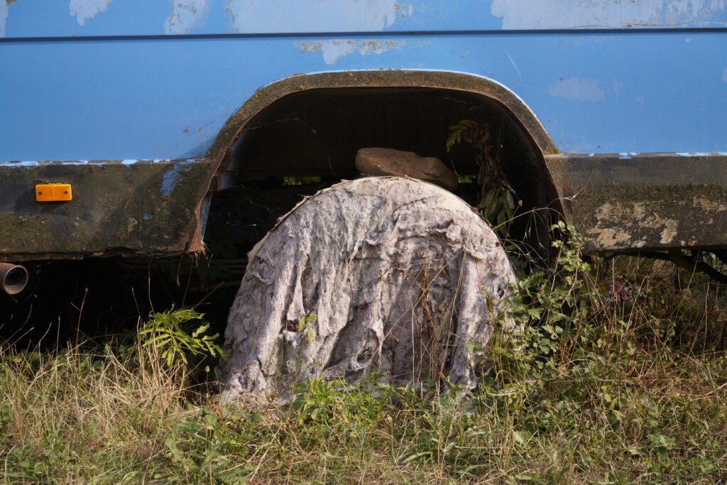 Wheel well propped with stone and tarp