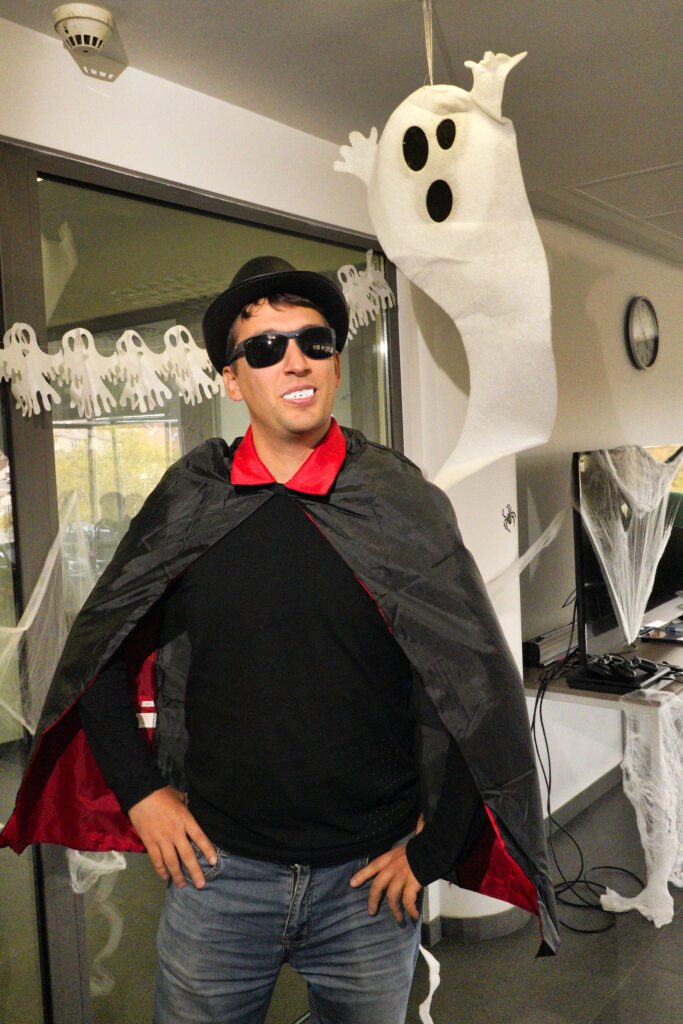 Vampire costume amid office Halloween decor