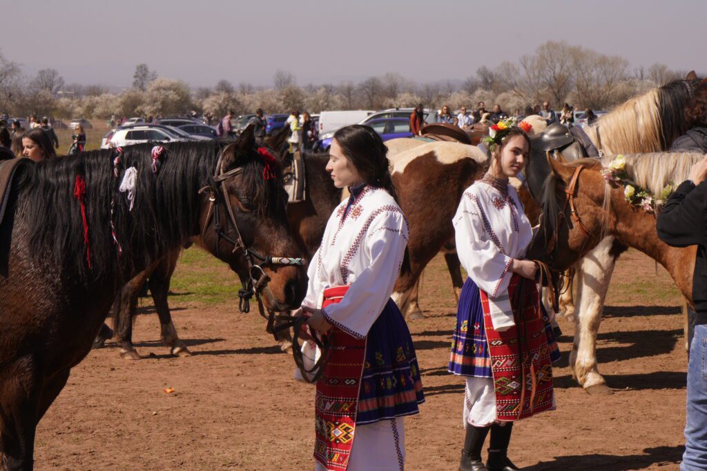 Women in folk dress with decorated horses