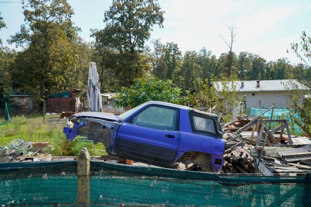 Stripped blue SUV in a rural yard, documentary photography