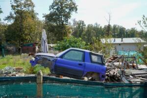 Stripped blue SUV in a rural yard, documentary photography