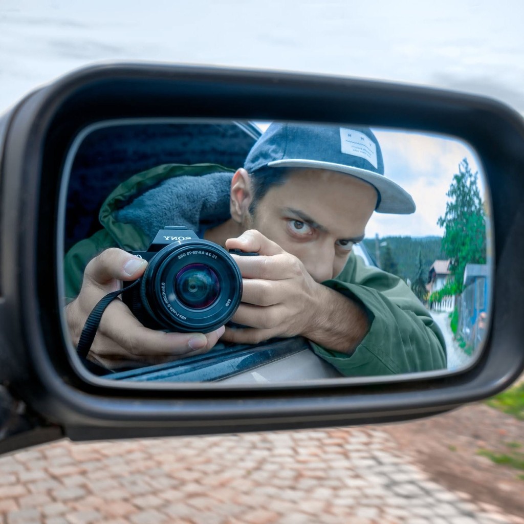 Self-portrait of Todor Stoyanov photographing himself in a car side-view mirror with a Sony camera